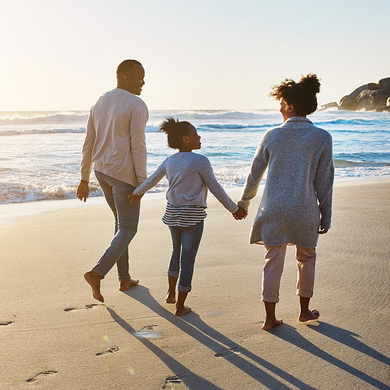 Family walking on the beach at sunset