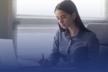 Female Professional Writing At Desk